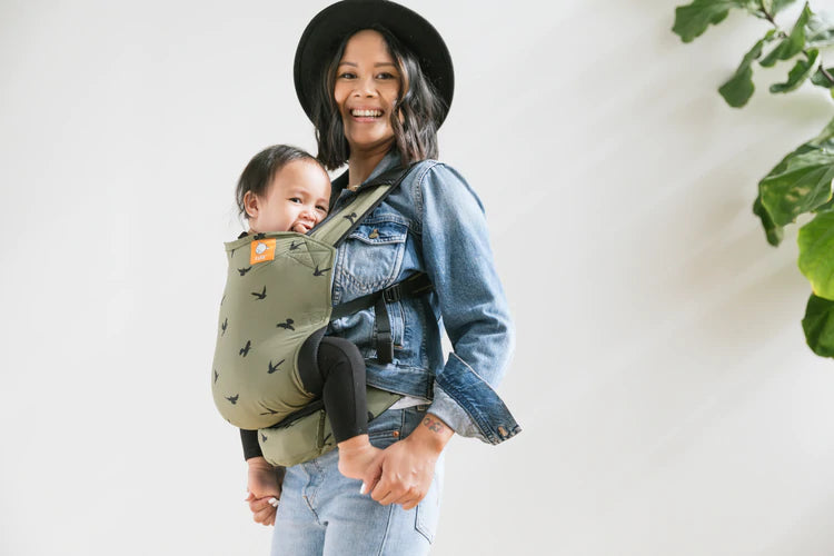 A mother carrying her son in a Tula Lite in front-carry position.