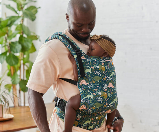 Papà che porta il suo bambino nel marsupio Tula Free-to-Grow Lanf Before Tula