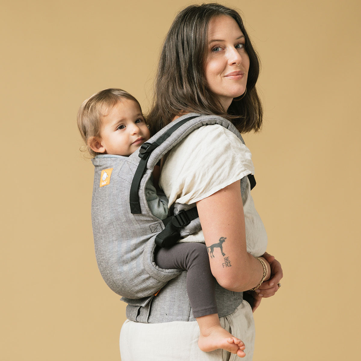 Mama niosąca dziecko na plecach w nosidełku Tula Free-to-Grow Baby Carrier