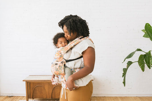 A mother snuggling her baby in a Tula Baby Carrier..