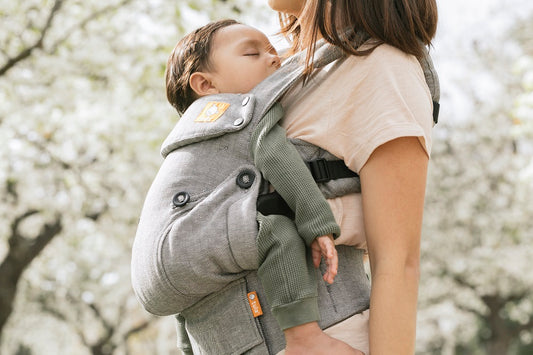 A baby sleeping in a Tula Baby Carrier.