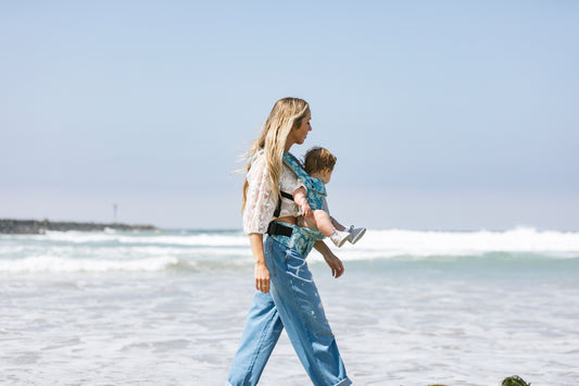 A mother and her baby using a Tula Carrier in forward-facing position.