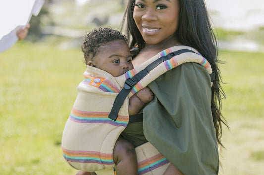 A mother who is carrying her child in front-carry position.