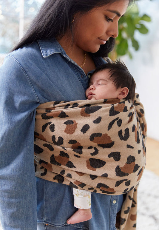 A baby sleeping in a ring sling.