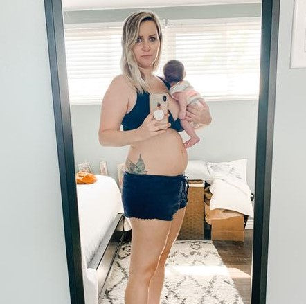 A mother taking a mirror selfie with her newborn.