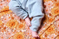A photo of baby's feet on Tula Sunflower Swaddle Blanket made from tencel