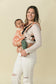 Mom babywearing a happy child in inward facing position