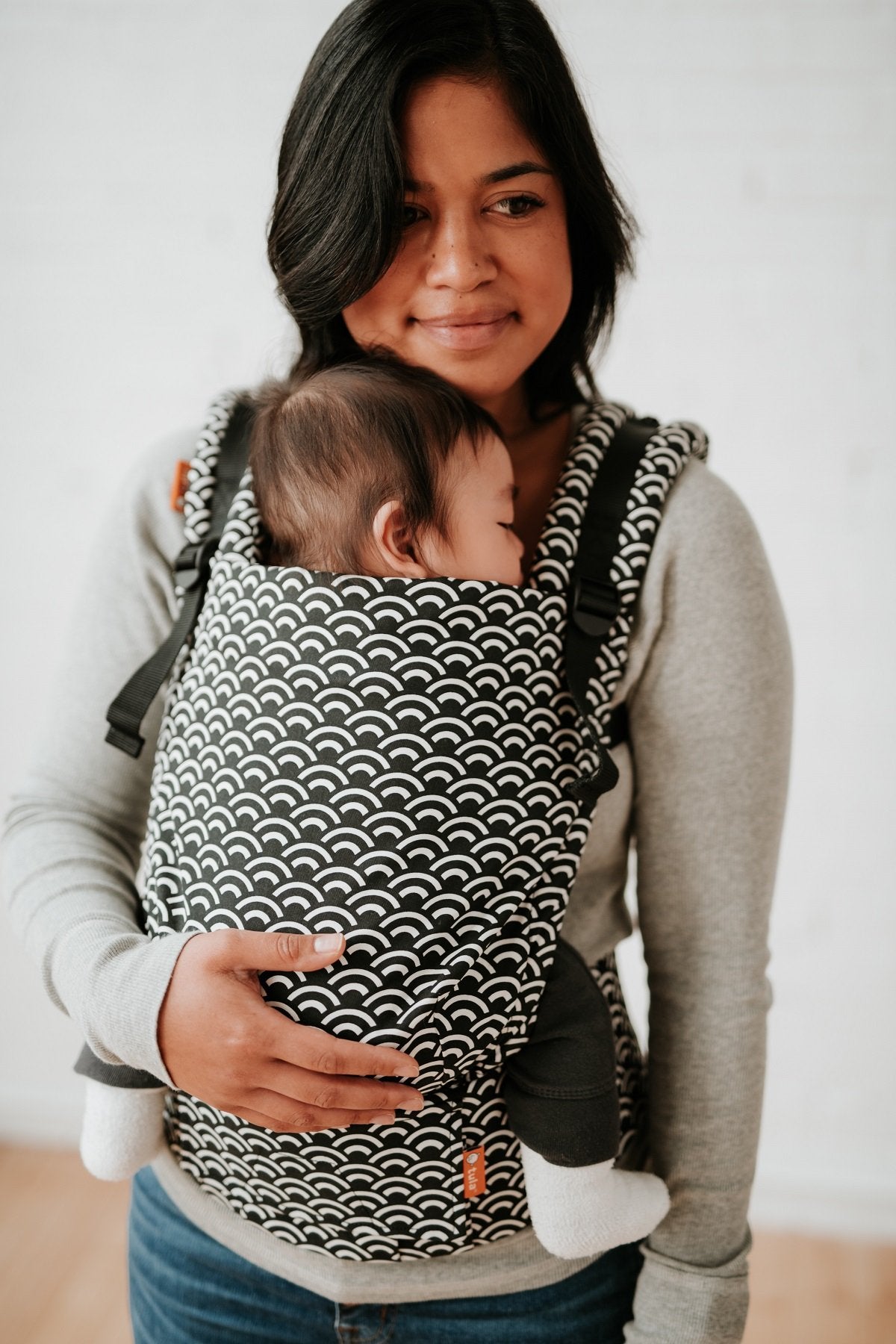 A baby sleeping in the Free-to-Grow Carrier Tempo in front-carry position.