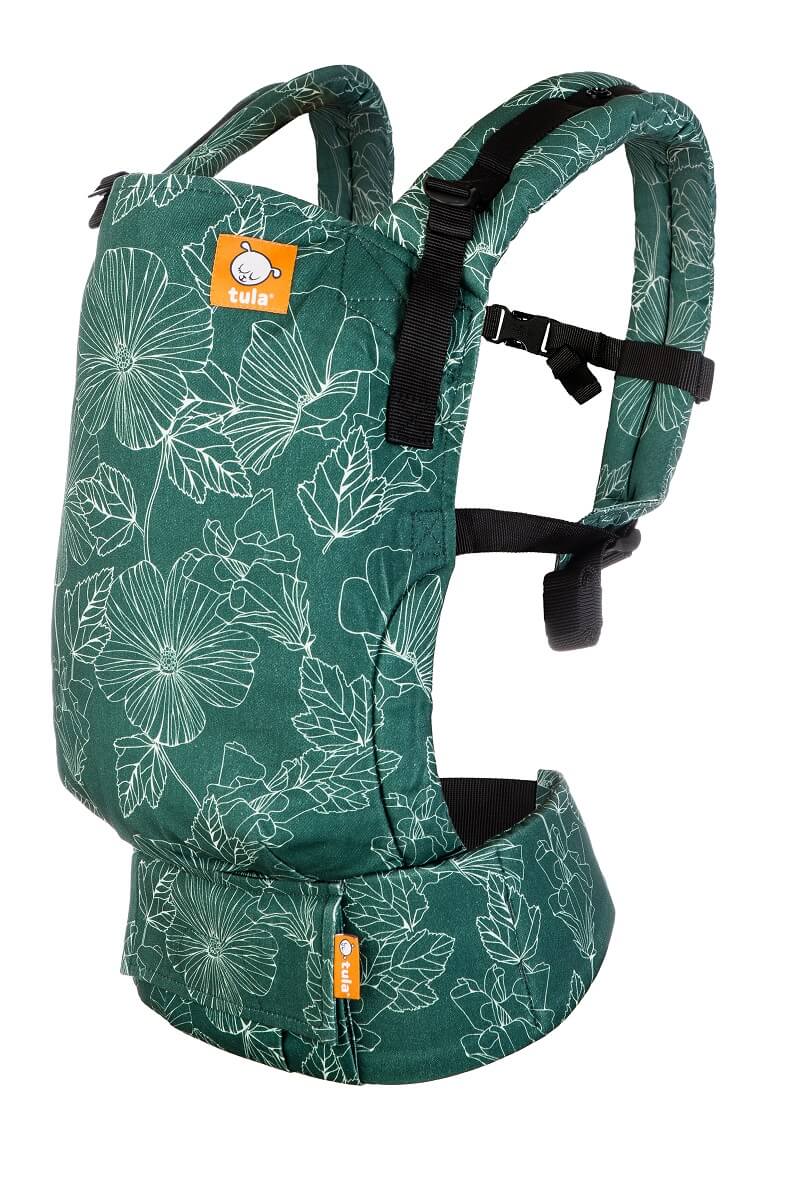 The ergonomic Tula Free-to-Grow Baby Carrier Harper with  lightly stenciled florals in crisp white against a forest green background.