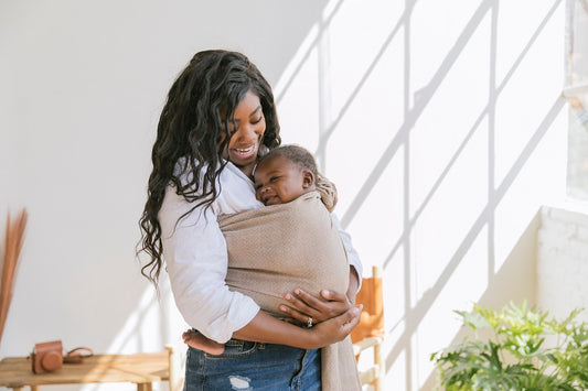 Una madre lleva a su hijo en un Ring Sling.