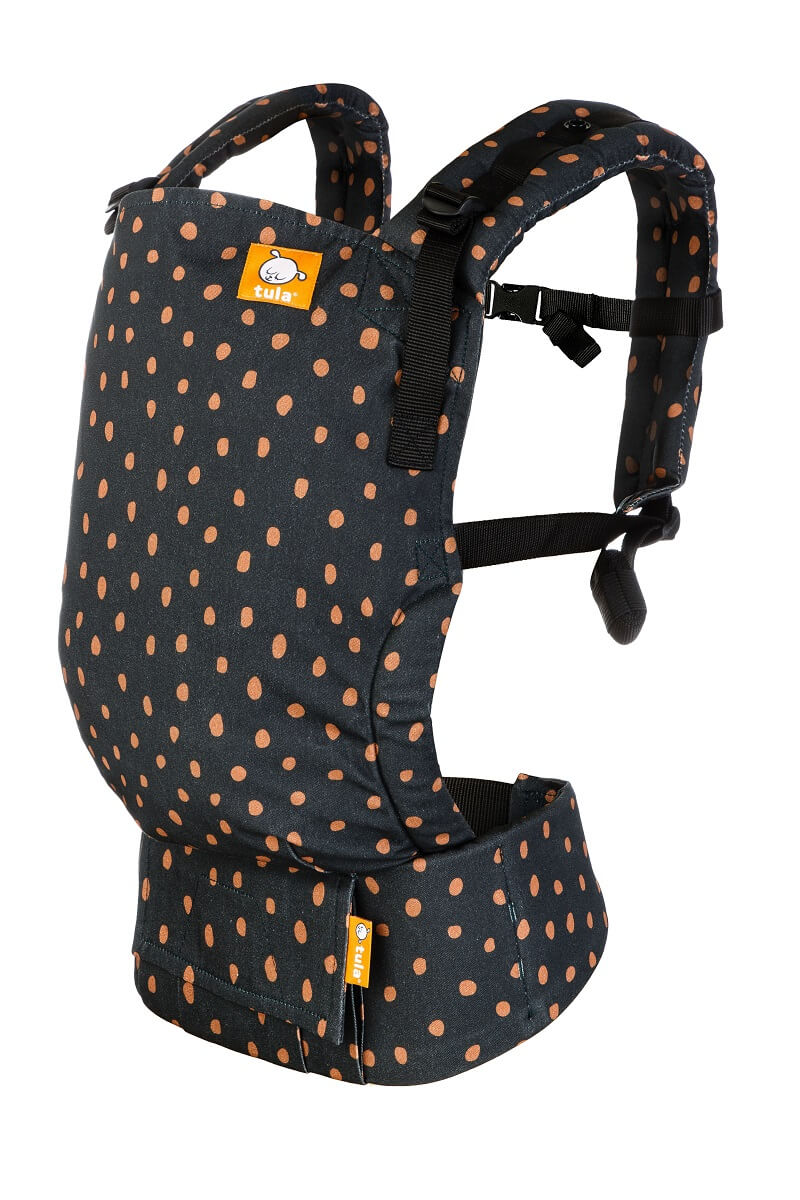 Un portabebés ergonómico Free-to-Grow  Ginger Dots  con puntos de arcilla sobre fondo oscuro.