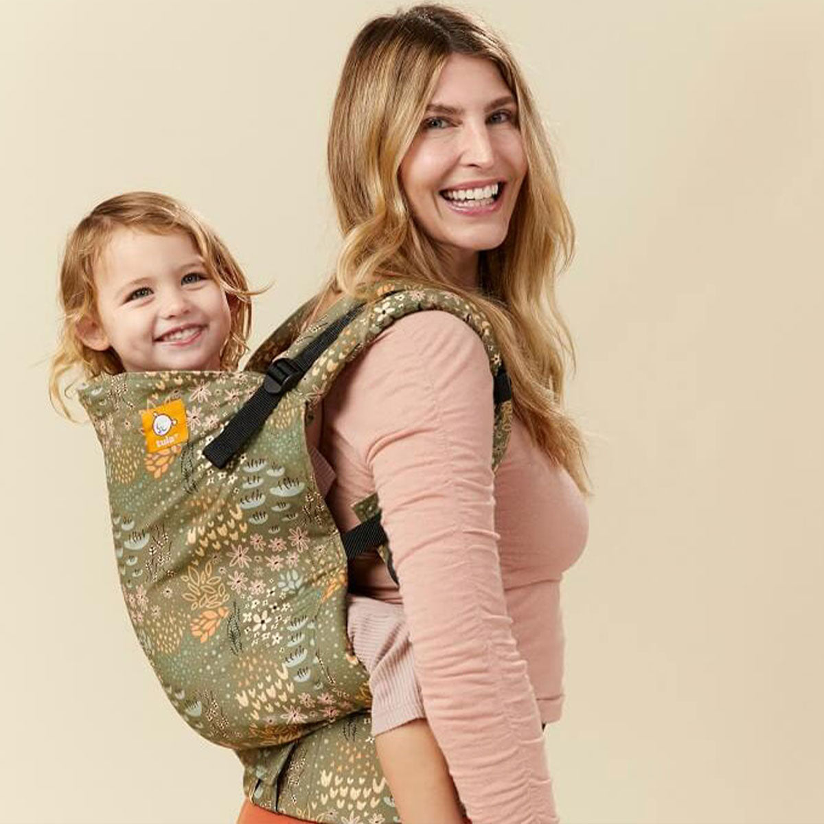 Äiti kantaa tytärtään selässään Tula Toddler -kantorepussa