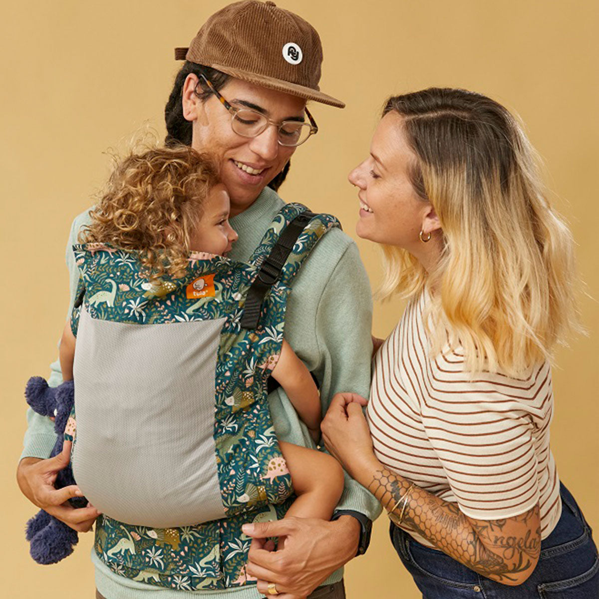 Pariskunta kuljettaa vauvaansa kasvot sisäänpäin suuntautuvassa asennossa Tula Toddler Kantorepussa