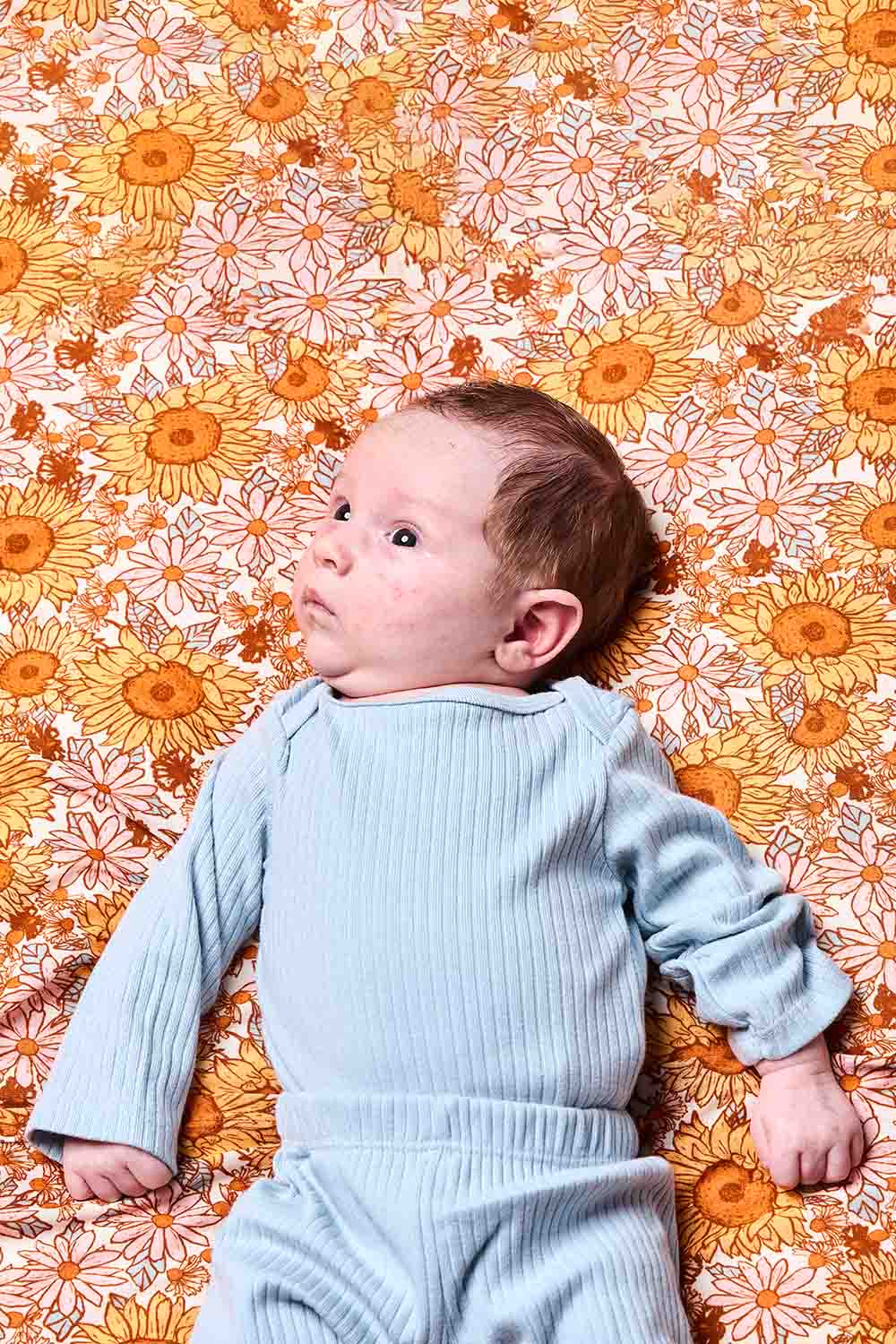 Kuva vastasyntyneestä, jonka päällä on Tula Sunflower Swaddle Blanket, joka on valmistettu tencelistä.