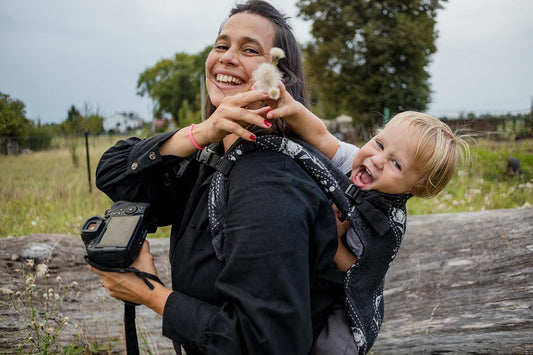 Maman photographe et son enfant dans le porte-bébé Tula