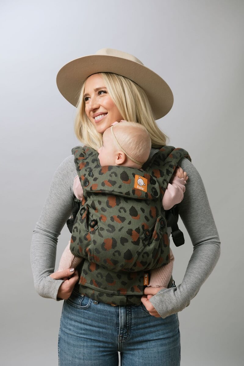 Une mère et son enfant utilisant le porte-bébé Signature Explore  Olive Leopard  en position de portage avant.