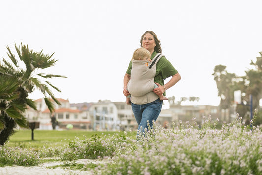 Una madre che porta il suo bambino attraverso la natura.