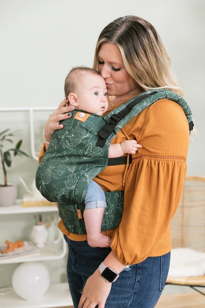 Un bambino seduto nell'ergonomico Tula Free-to-Grow Marsupio  Harper in posizione di trasporto anteriore.