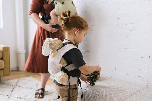 Een kind met zijn Mini Poppen Draagzak van Tula.