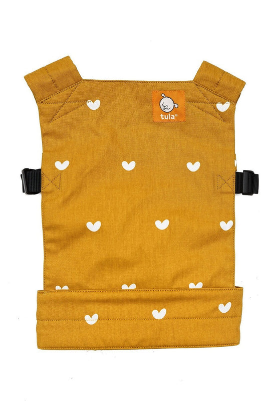 De Poppen Draagzak Play  heeft een ontwerp met kleine witte hartjes die fladderen over een mosterdgele achtergrond.