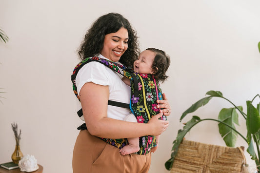 Uma mãe com o seu bebé num porta-bebé Tula Mikoleon Signature Carrier.