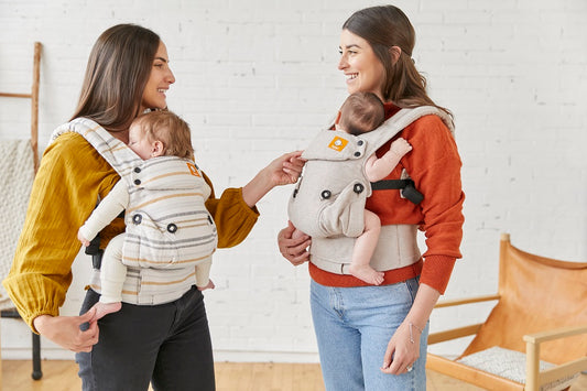 Duas mães e os seus filhos que utilizam o porta-bebé Tula.