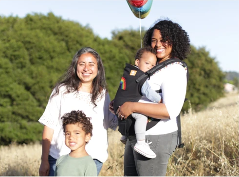 Uma família feliz de quatro pessoas à porta.